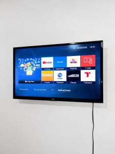 a flat screen tv sitting on a white wall at Residencial Turístico Rio Guayas in Guayaquil +3 photos