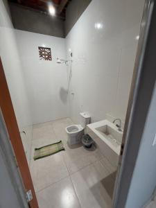 a white bathroom with a toilet and a sink at Recanto da vale Rs in Três Marias