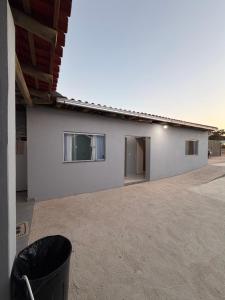 a white building with two windows and a trash can at Recanto da vale Rs in Três Marias