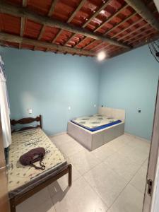 two beds in a room with blue walls at Recanto da vale Rs in Três Marias