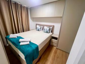 a small bedroom with a bed with towels on it at Apartamento 2 quartos com Vista in Bauru