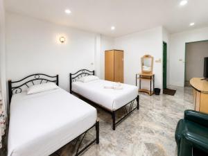 two beds in a room with a tv at โรงแรมลักเซอรี่ Luxury Hotel in Kanchanaburi City +6 photos