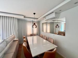a dining room with a table and chairs and a couch at Apartamento 2 quartos com Vista in Bauru