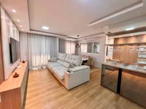 a living room with a white couch and a table at Apartamento 2 quartos com Vista in Bauru