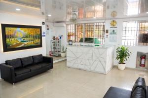 a lobby with a black couch and a counter at HOTEL BOUTIQUE SONNE BALOP Valledupar in Valledupar