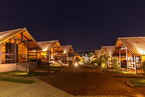 a row of wooden houses at night at Cabanas Charme da Serra in Cambará