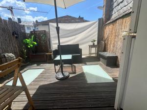 a patio with an umbrella and chairs on a deck at Old Town Terrace Studio Trier in Trier