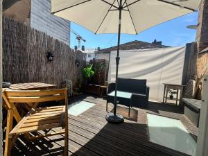 a patio with a table and an umbrella on a deck at Old Town Terrace Studio Trier in Trier