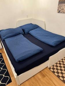 a bed with blue sheets on top of it at Old Town Terrace Studio Trier in Trier