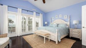 a blue bedroom with a bed and a chair at Pristine Islamorada Pool Home with Ocean View and Dockage in Islamorada