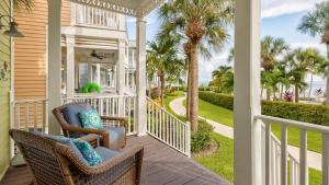 a porch with wicker chairs and palm trees at Pristine Islamorada Pool Home with Ocean View and Dockage in Islamorada