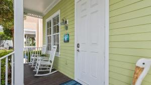 a green house with a door and chairs on a porch at Pristine Islamorada Pool Home with Ocean View and Dockage in Islamorada +37 photos
