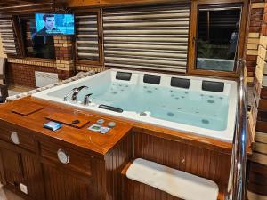 eine große Badewanne in einem Zimmer mit Fernseher in der Unterkunft Ranch Diamond Sarajevo with Jacuzzi in Vogošća