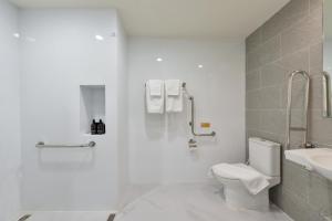 a white bathroom with a toilet and a sink at SENS Hotel Nonthaburi Bangbuathong in Nonthaburi +10 photos