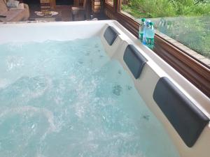 ein Whirlpool mit Wasser und zwei Flaschen Wasser in der Unterkunft Ranch Diamond Sarajevo with Jacuzzi in Vogošća