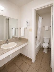 a white bathroom with a sink and a toilet at Silver Queen Inn in Kingman +12 photos