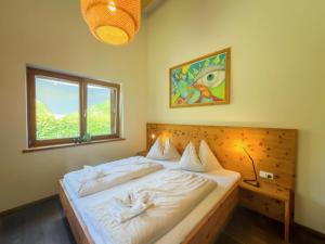 a bedroom with a bed with white sheets and a window at Auen 53 in Lake Pressegg