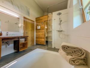 a bathroom with a tub and a glass shower at Auen 53 in Lake Pressegg +62 photos