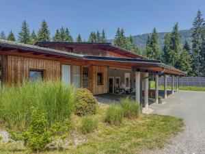a wooden house with a porch and a driveway at Auen 53 in Lake Pressegg