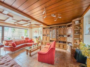 a living room with red furniture and a wooden ceiling at Landhaus Herz der Tauern in Mallnitz