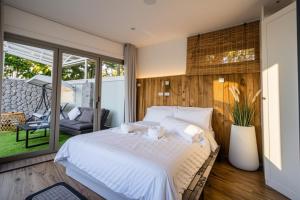 a bedroom with a large white bed and a patio at Absolute Oceanfront Tara Villa Beachfront 4 Bed in Ban Saiyuan (1) +92 photos