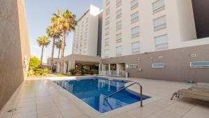 a swimming pool in front of a hotel at Holiday Inn Express Guadalajara Aeropuerto by IHG in Guadalajara