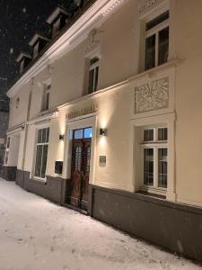 a white building with a brown door on a street at Hotel Rauch in Attendorn