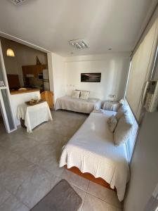 a hotel room with two beds and a kitchen at Alem plaza apart in Comodoro Rivadavia