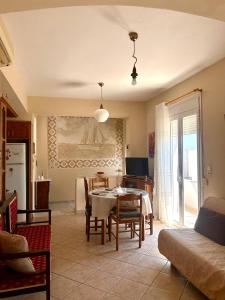 a living room with a table and a kitchen at Komi Seaside Living in Kómi