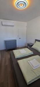 a room with two beds and a ceiling at Apartmán Hrdličky Trenčín in Trenčín