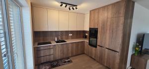 a kitchen with wooden cabinets and a sink and a refrigerator at Apartmán Hrdličky Trenčín in Trenčín +7 photos