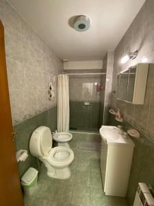 a bathroom with a toilet and a sink at Alem plaza apart in Comodoro Rivadavia