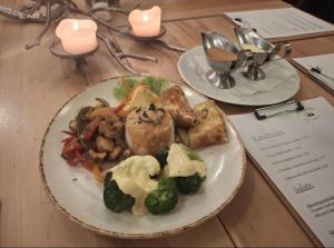 a plate of food with broccoli and meat on a table at Hotel Rauch in Attendorn +8 photos