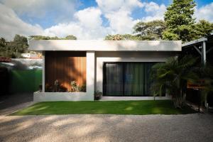 a small white house with a grass yard at Akari Privè in Barranca