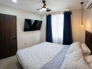 a bedroom with a bed and a television on the wall at Akari Privè in Barranca +27 photos