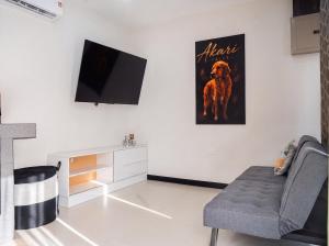a living room with a chair and a tv on a wall at Akari Privè in Barranca