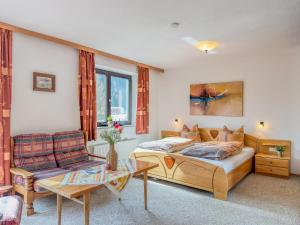 a bedroom with a bed and a couch at Landhaus Herz der Tauern in Mallnitz +39 photos