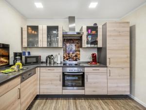 a kitchen with stainless steel appliances and wooden cabinets at Mompels in Rübeland