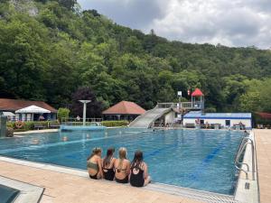 three girls in bikinis sitting in front of a swimming pool at Mompels in Rübeland