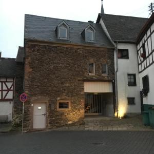 een oud stenen gebouw met een garage in een straat bij Casa Manderscheid in Manderscheid