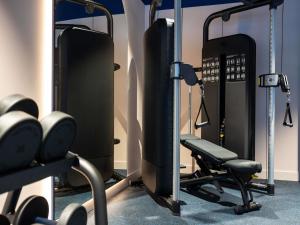 a gym with a chair and weights at TRIBE Hotel Den Haag Centraal - Opened December 2025 in The Hague