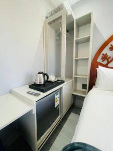 a room with a bed and a desk with a tea kettle on it at MAISON MOSH ll GUEST HOUSE in Maseru