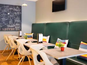 a dining room with tables and chairs and a chalkboard at ibis Leuven Centrum in Leuven