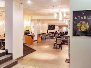 a dining room with tables and chairs and a restaurant at Novotel Paris Orly Rungis Aéroport in Rungis