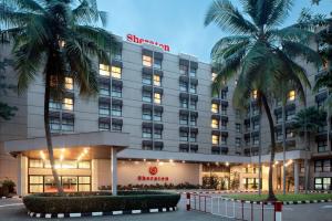 a hotel with palm trees in front of it at Sheraton Lagos Hotel in Lagos