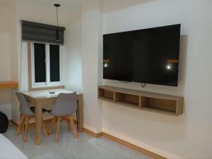 a living room with a table and a television on a wall at Maganda Hotel - San Fernando in San Fernando