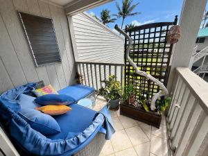 a bed on a balcony with pillows on it at Wavecrest - 4BR Condos - Sleeps 12 in Kaunakakai