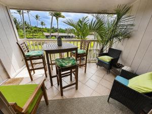 a balcony with a table and chairs and a view at Wavecrest - 4BR Condos - Sleeps 12 in Kaunakakai