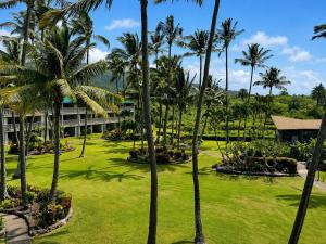 an exterior view of the resort with palm trees at Wavecrest - 4BR Condos - Sleeps 12 in Kaunakakai