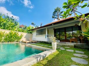a villa with a swimming pool in front of a house at Ubud jungle House behind bintang supermarket ubud in Ubud